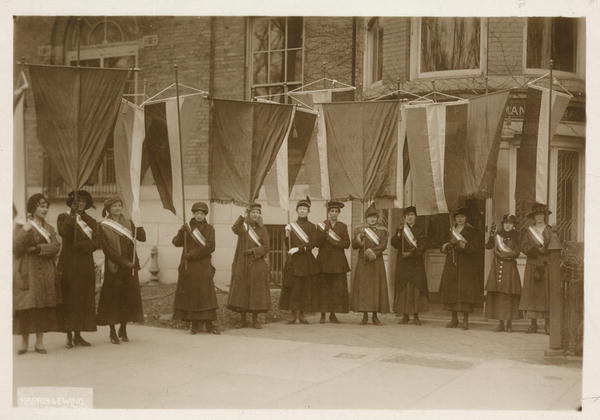 Suffragettes carrying banners